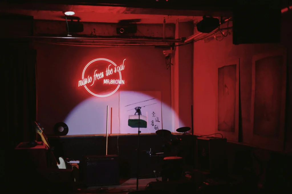 Un bar de jazz con un cartel de neón que dice "La música libera el alma" en un ambiente vibrante.