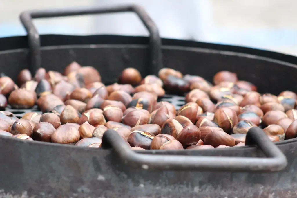 Primer plano de castañas asadas en una parrilla, tradición típica de La Castanyada en Cataluña durante el otoño.