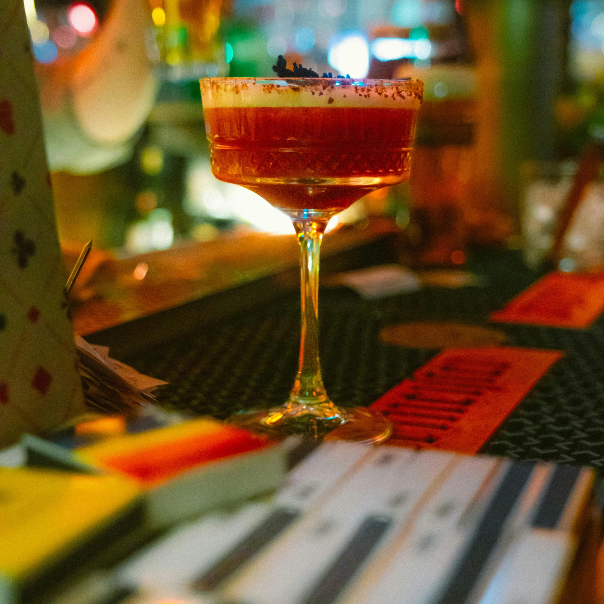 A close-up of a craft cocktail in a stylish Barcelona bar, surrounded by dim lighting and a cozy ambiance.