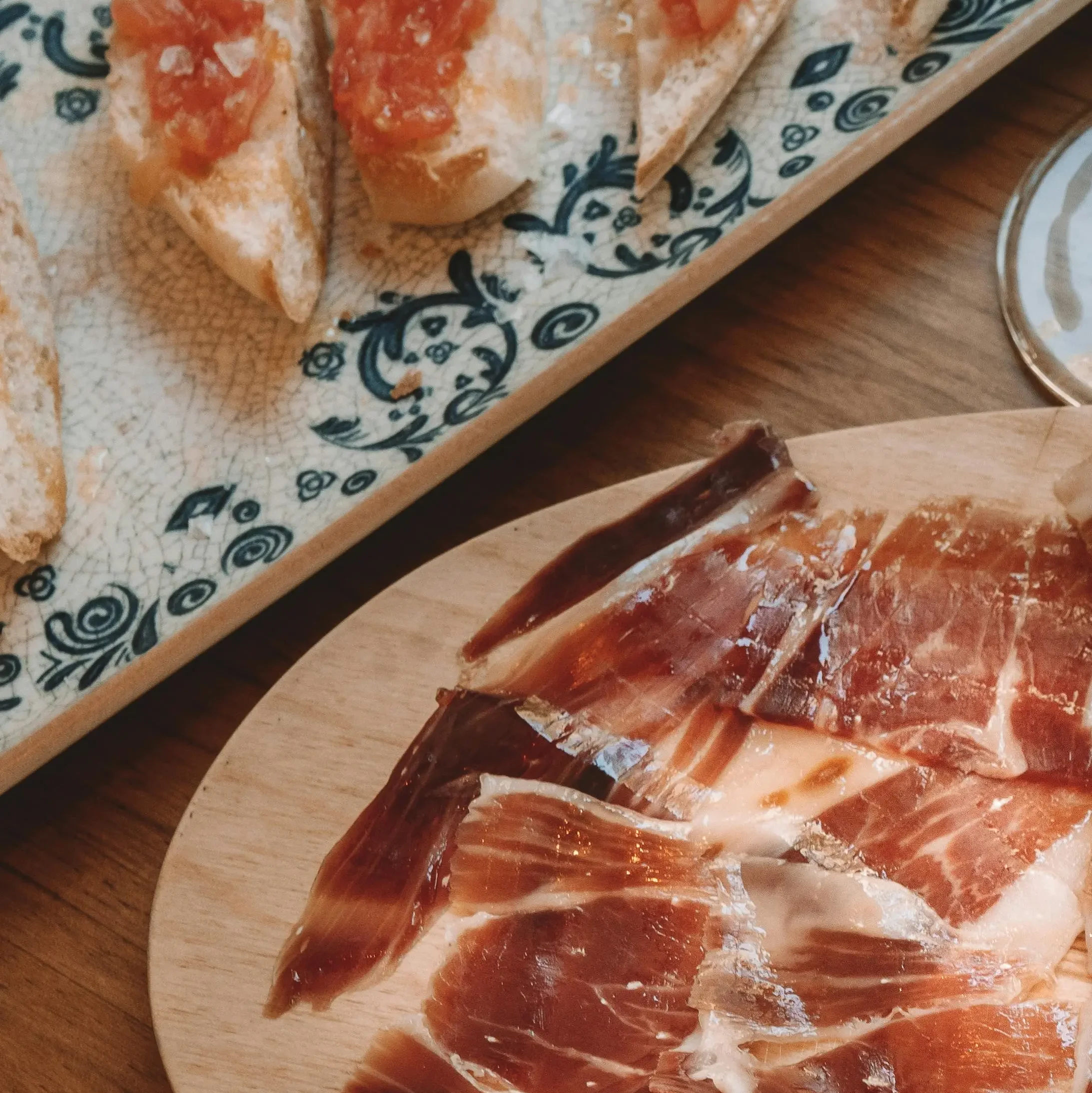 Iberico ham and tomato with bread laid out on a table