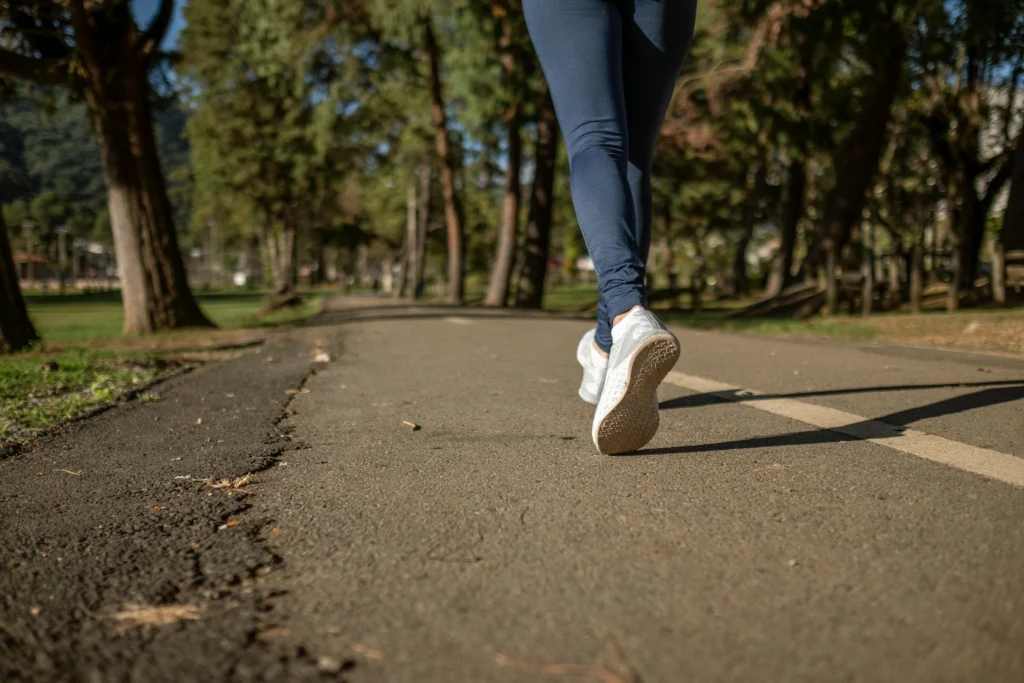 Person jogging on a park trail surrounded by trees in Barcelona