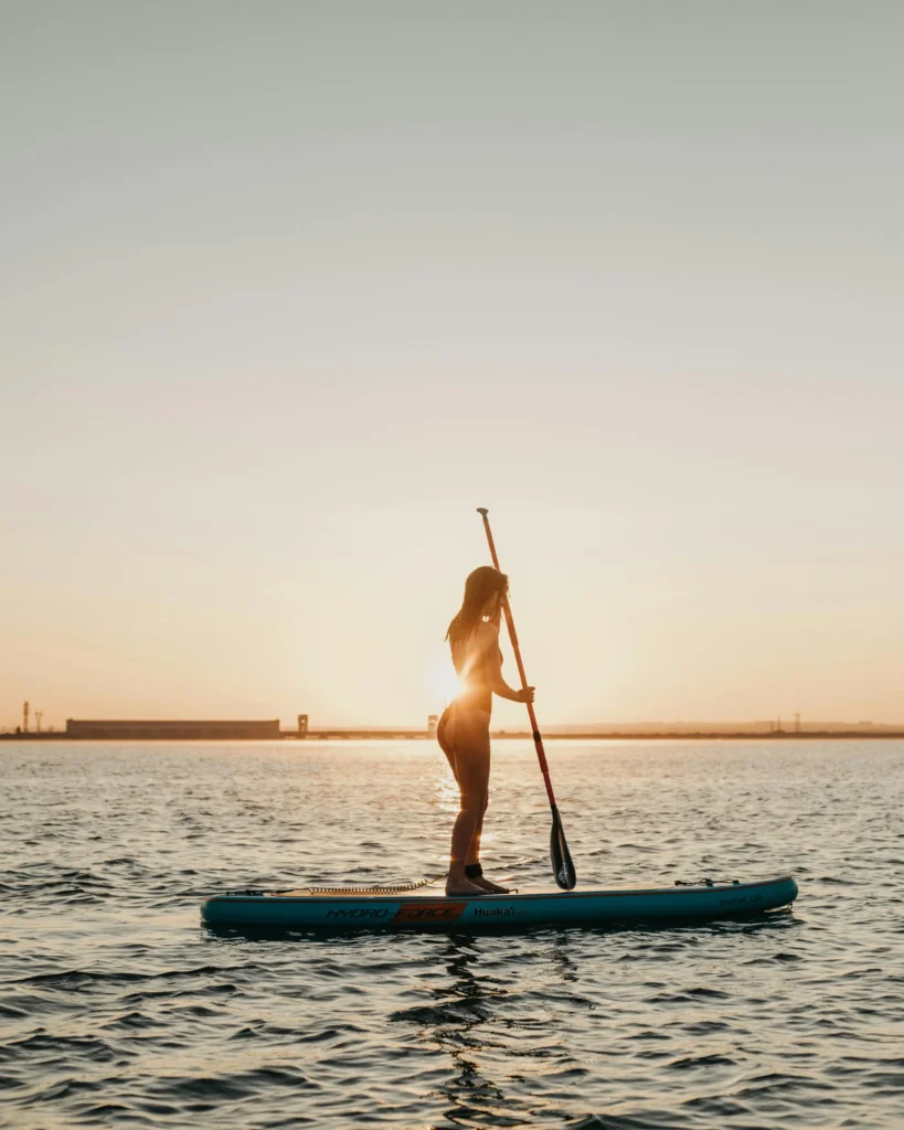 Woman paddleboarding at sunset on the sea in Barcelona