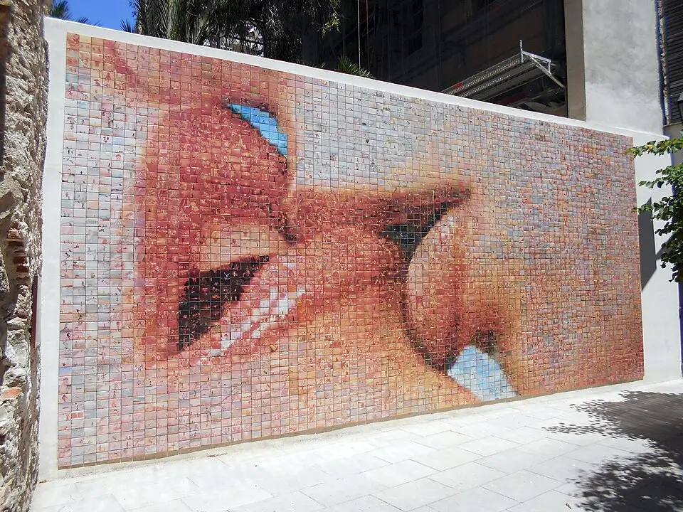 Mural ubicado en Barcelona que representa un beso gigante compuesto por cientos de pequeñas fotografías, titulado "El mundo nace en cada beso".