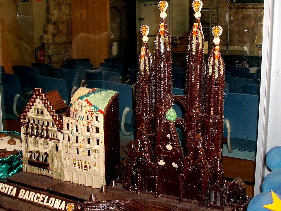 Modelos comestibles de la Sagrada Familia y la Casa Batlló, hechos completamente de chocolate, exhibidos en el Museo del Chocolate de Barcelona, con el texto "Visita Barcelona" en la base.