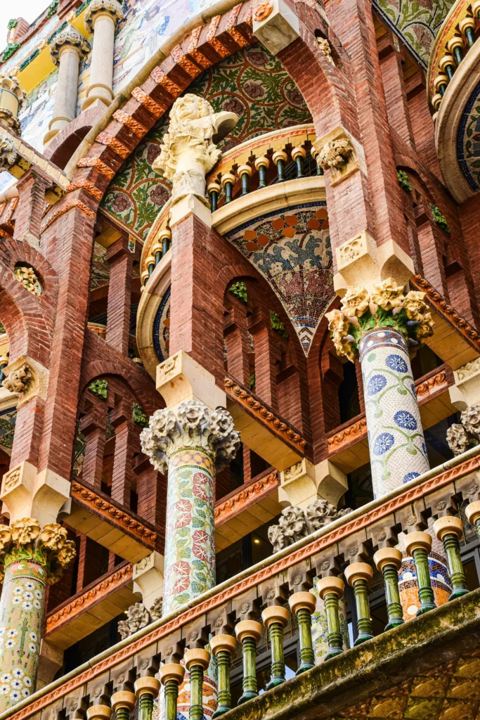 Primer plano de las columnas decoradas con mosaicos coloridos y detalles arquitectónicos del Palau de la Música Catalana, uno de los edificios más emblemáticos de Barcelona.