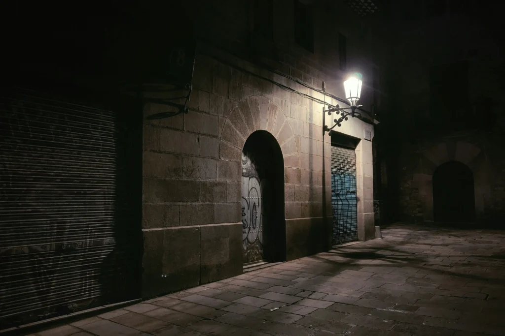 Pasillo con arcos iluminado tenuemente en el Born de Barcelona, creando una atmósfera misteriosa perfecta para un tour de leyendas y fantasmas.