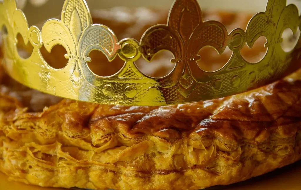 Primer plano de un Roscón de Reyes con una corona dorada encima, típico postre del Día de Reyes en España.