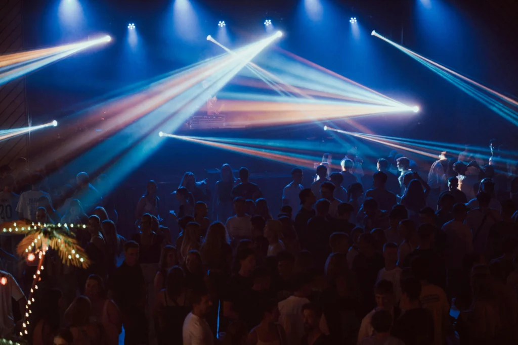 Grupo de personas bailando bajo luces de colores en una discoteca de Barcelona durante la noche de Nochevieja.
