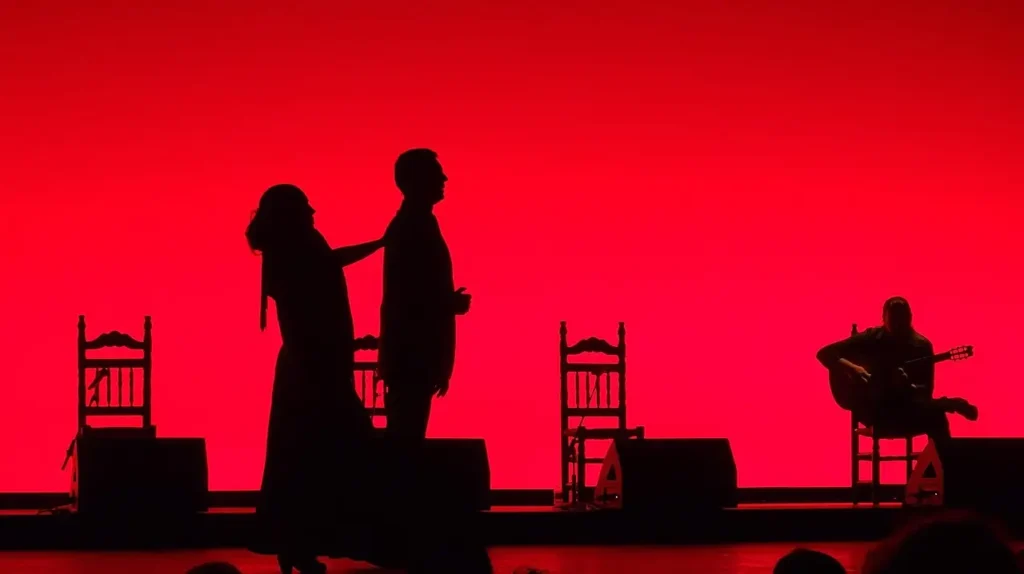 Artistas de flamenco actuando sobre un escenario iluminado en tonos rojos, una opción popular para disfrutar de la noche de Nochevieja en Barcelona.