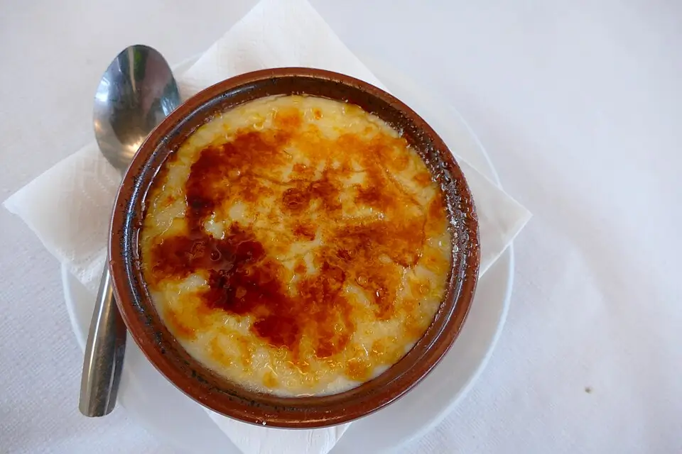 Crema Catalana served in a traditional clay dish, with a golden caramelised top— a classic dessert ideal for Christmas celebrations.