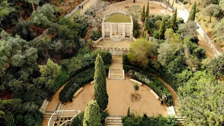 Vista elevada de los jardines del Parc del Guinardó en Barcelona con senderos, escaleras, vegetación abundante y zonas ajardinadas rodeadas de naturaleza.
