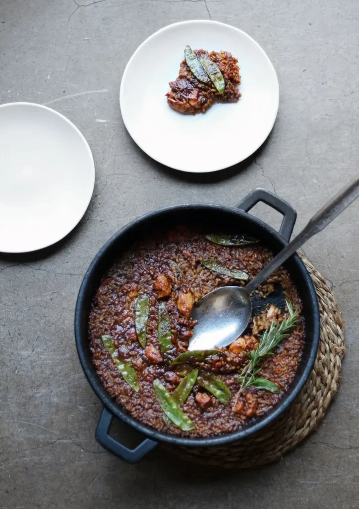 Arroz mediterráneo servido en sartén tradicional con verduras y hierbas aromáticas, presentado en un restaurante de Barcelona con una cuidada propuesta gastronómica inspirada en los sabores del Mediterráneo.