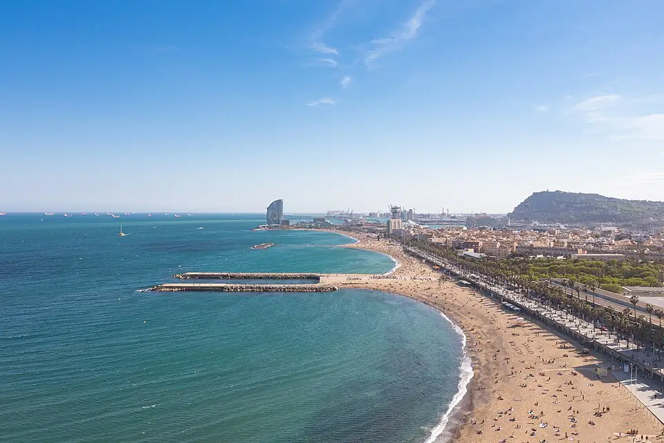 Vista aérea de la Playa del Somorrostro en Barcelona, con el paseo marítimo, el mar Mediterráneo y el Hotel W al fondo.