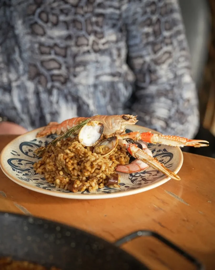 Plato de arroz de marisco con cigalas, almejas y mariscos servido en un restaurante de La Barceloneta, una de las especialidades gastronómicas más populares junto al litoral de Barcelona.