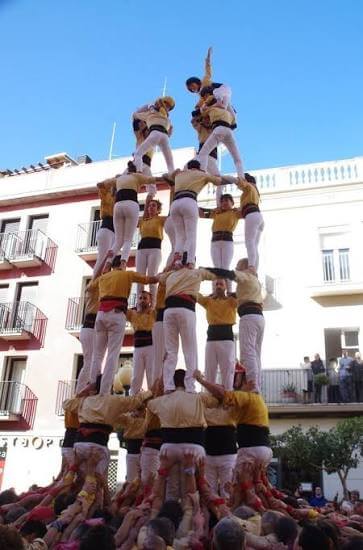 castellers formando una torre humana durante una fiesta tradicional en Cataluña