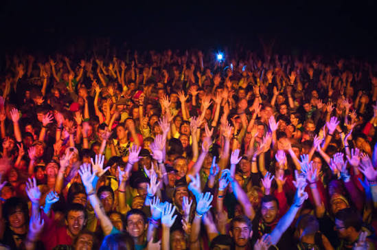 multitud en un festival con los brazos levantados 