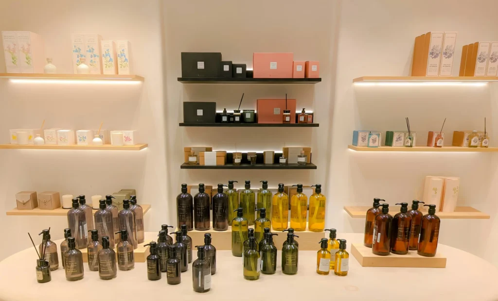 Étagères et présentoirs remplis de parfums, bougies et produits de soins corporels dans une boutique moderne de Barcelone.