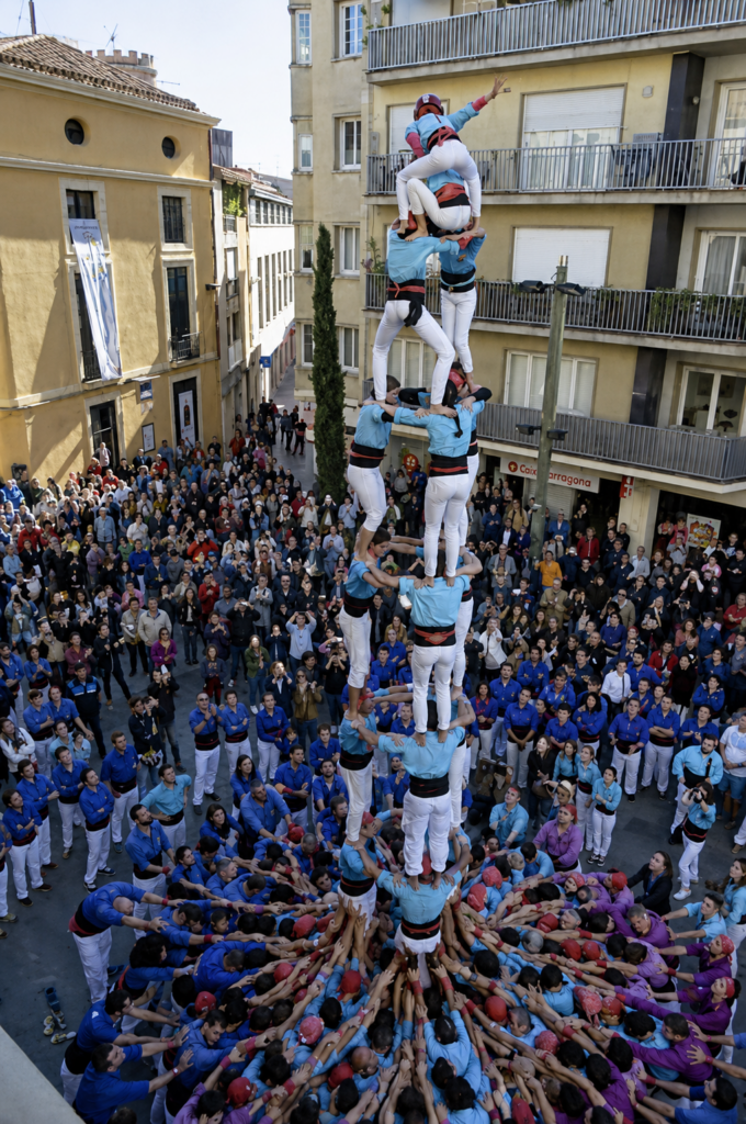 castellers forming a tower in a town square

