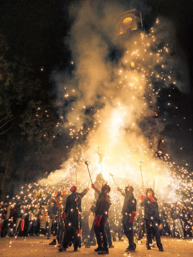 Correfoc traditionnel à Barcelone avec des participants entourés d'étincelles et de feux d'artifice lors d'une fête catalane nocturne.