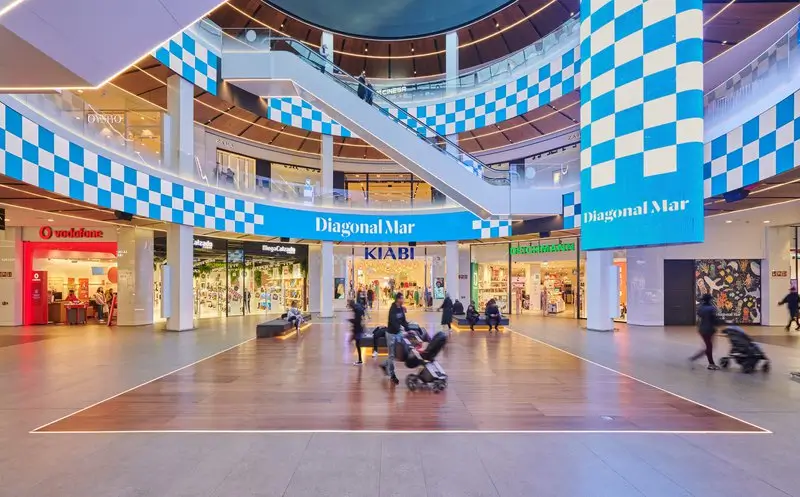 Interior del centro comercial Diagonal Mar en Barcelona, con tiendas y visitantes