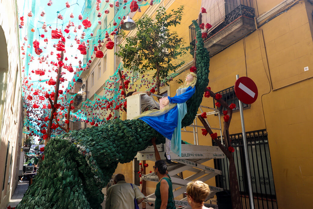 princess laying on a branch surrounded by red flowers
