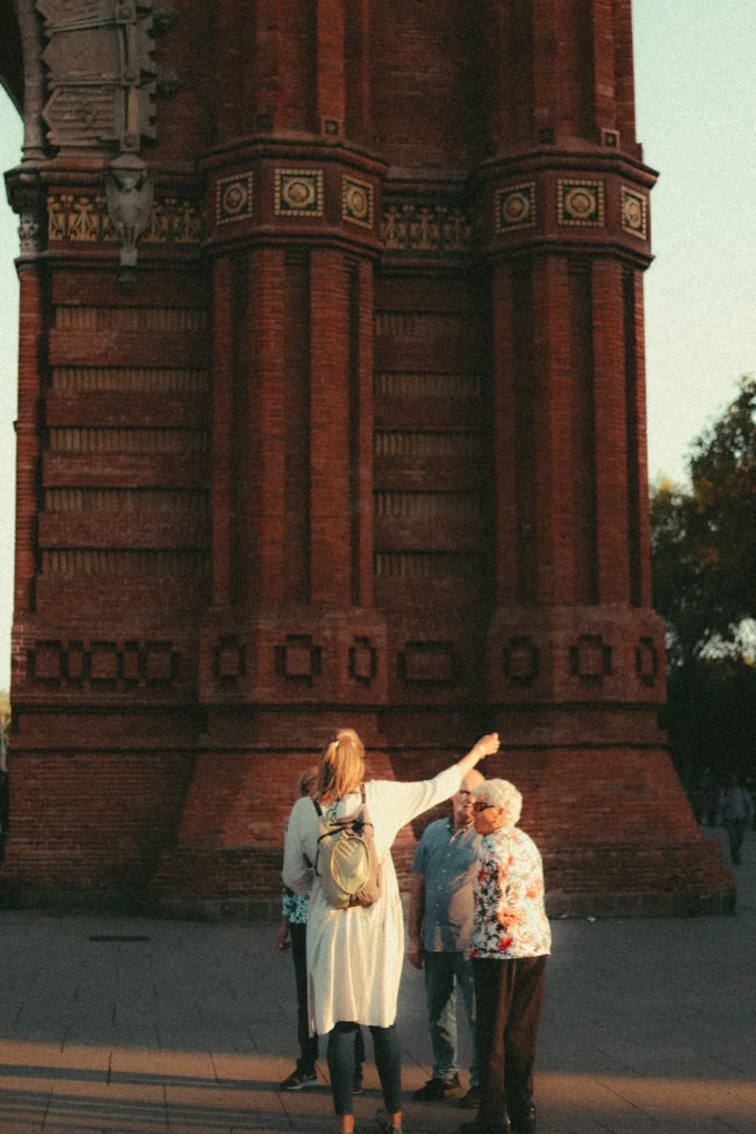 Visitors listening to a tour guide beside Barcelona’s Arc de Triomf during a guided walking tour