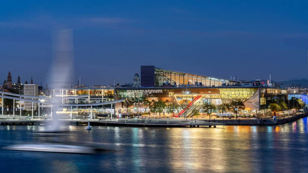 Centro comercial Maremagnum iluminado por la noche junto al mar en Port Vell, Barcelona