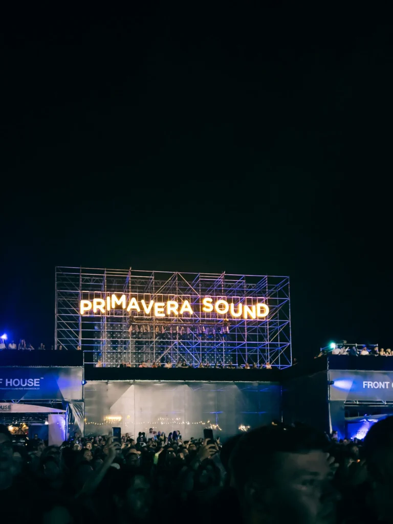 Night-time crowd at Primavera Sound festival at Parc del Fòrum in Barcelona, with the illuminated Primavera Sound sign above the venue.