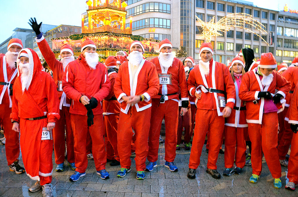 Participants dressed as Santa Claus taking part in a festive Christmas running event.