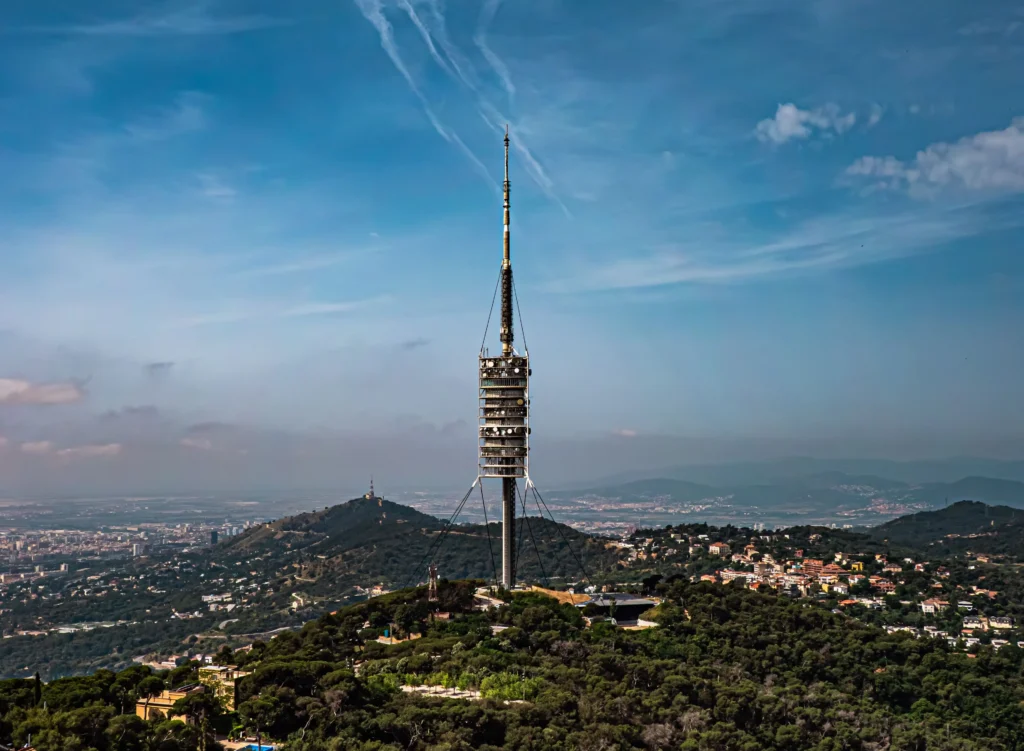Torre de Collserola rising above the green hills of the Collserola mountain range overlooking Barcelona.