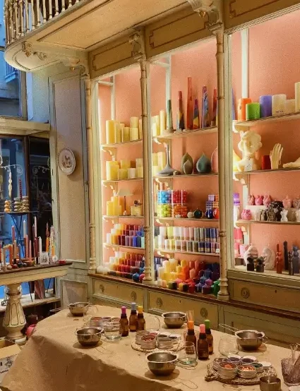 Interior of Cereria Subirà in Barcelona, featuring shelves filled with colourful handmade candles.