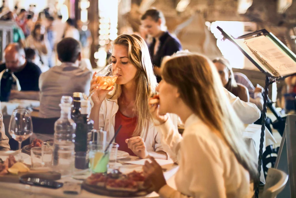 People enjoying food and drinks together at a lively restaurant in Barcelona.