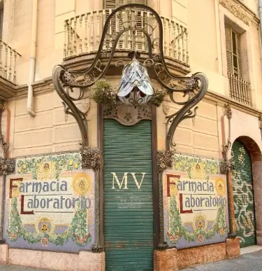 Historic pharmacy in Barcelona with an ornate Modernist façade, decorative tiles and original architectural details.