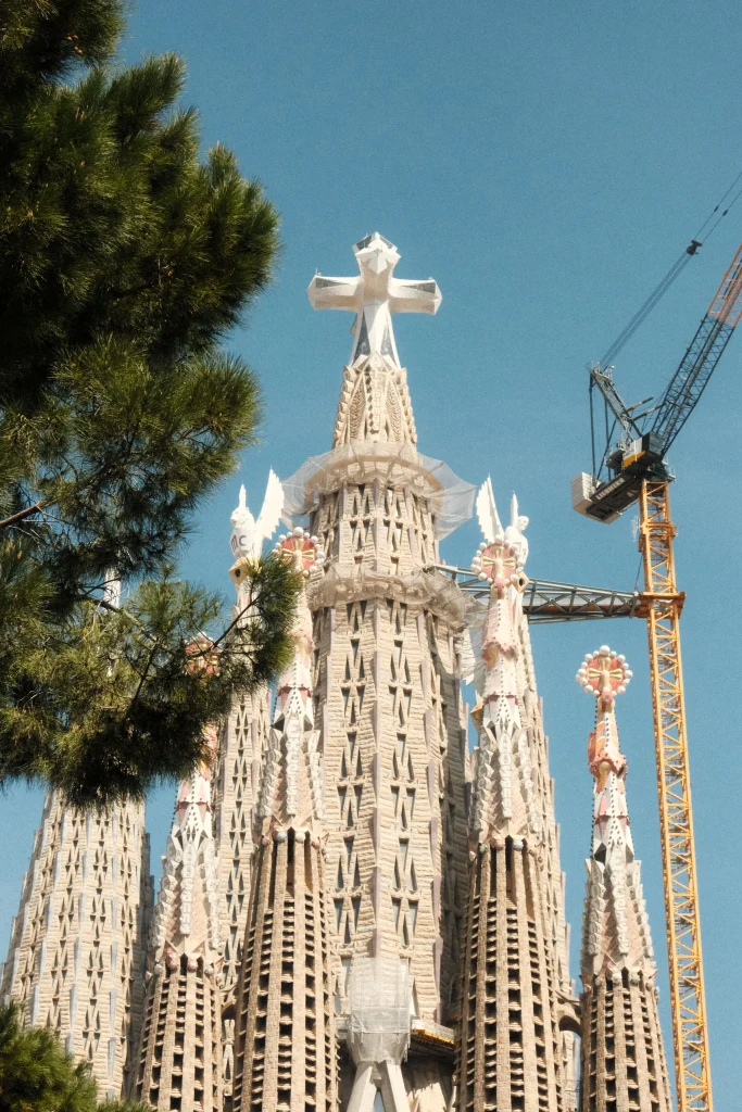 Close-up view of the Sagrada Familia towers and architectural details against a clear blue sky in Barcelona.