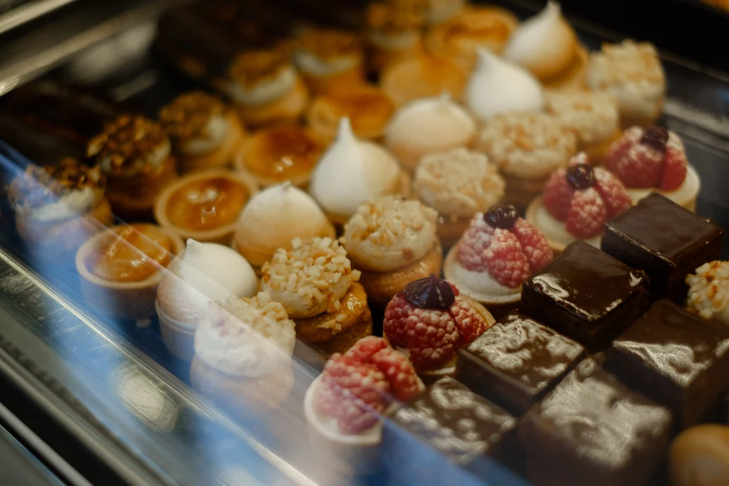 Selection of small pastries, chocolate cakes and fruit desserts displayed in a pastry shop in Barcelona.
