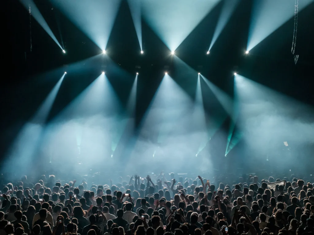 Gran multitud disfrutando de un evento de música electrónica con una espectacular iluminación de escenario en Barcelona.